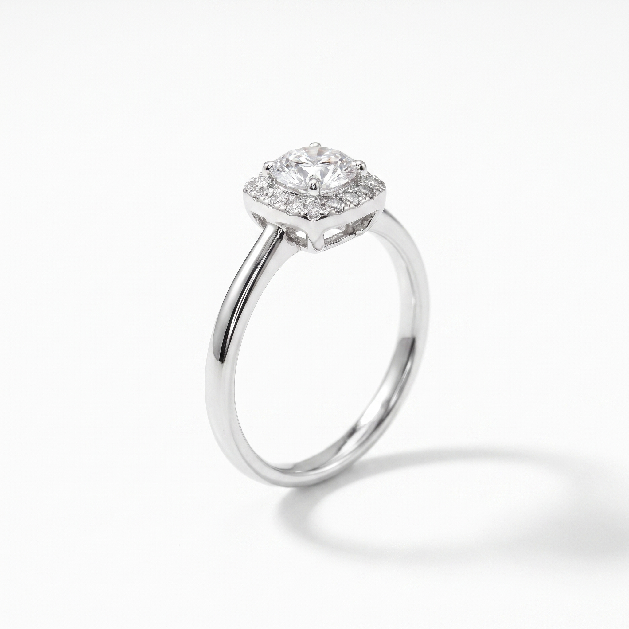 Round cushion halo engagement ring, three-quarter view, white gold shown
