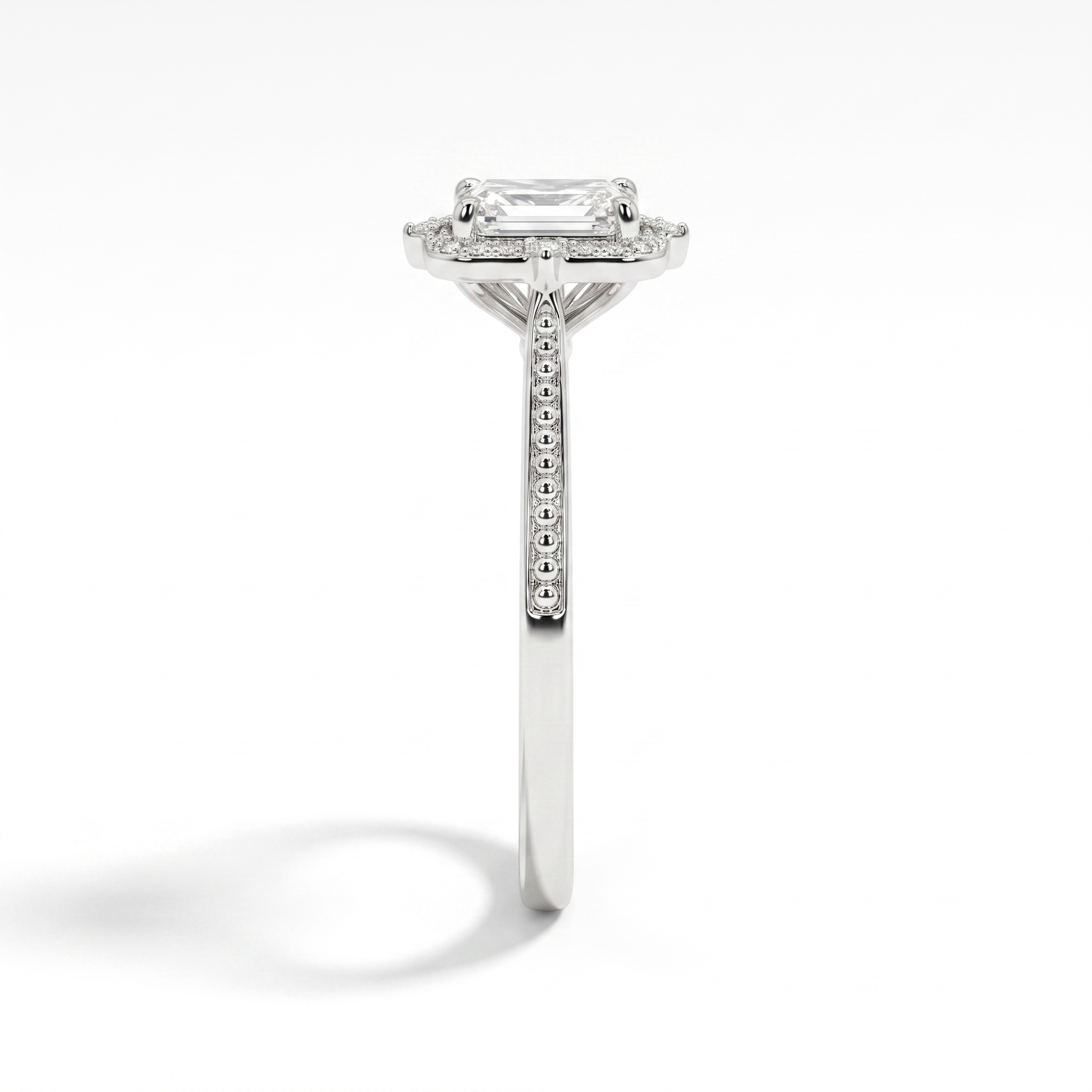 Emerald-cut halo engagement ring, side profile, white gold shown