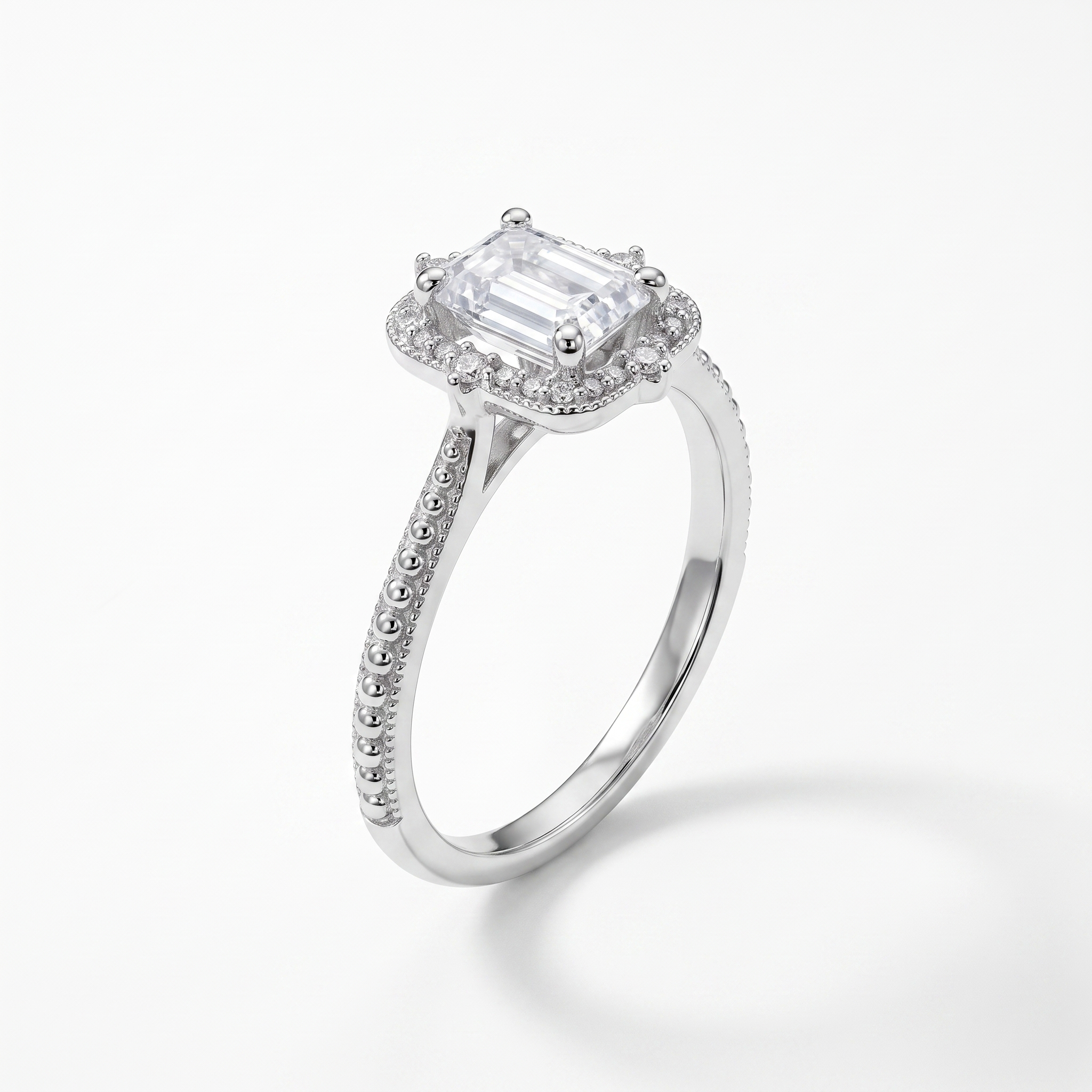 Emerald-cut halo engagement ring, three-quarter view, white gold shown